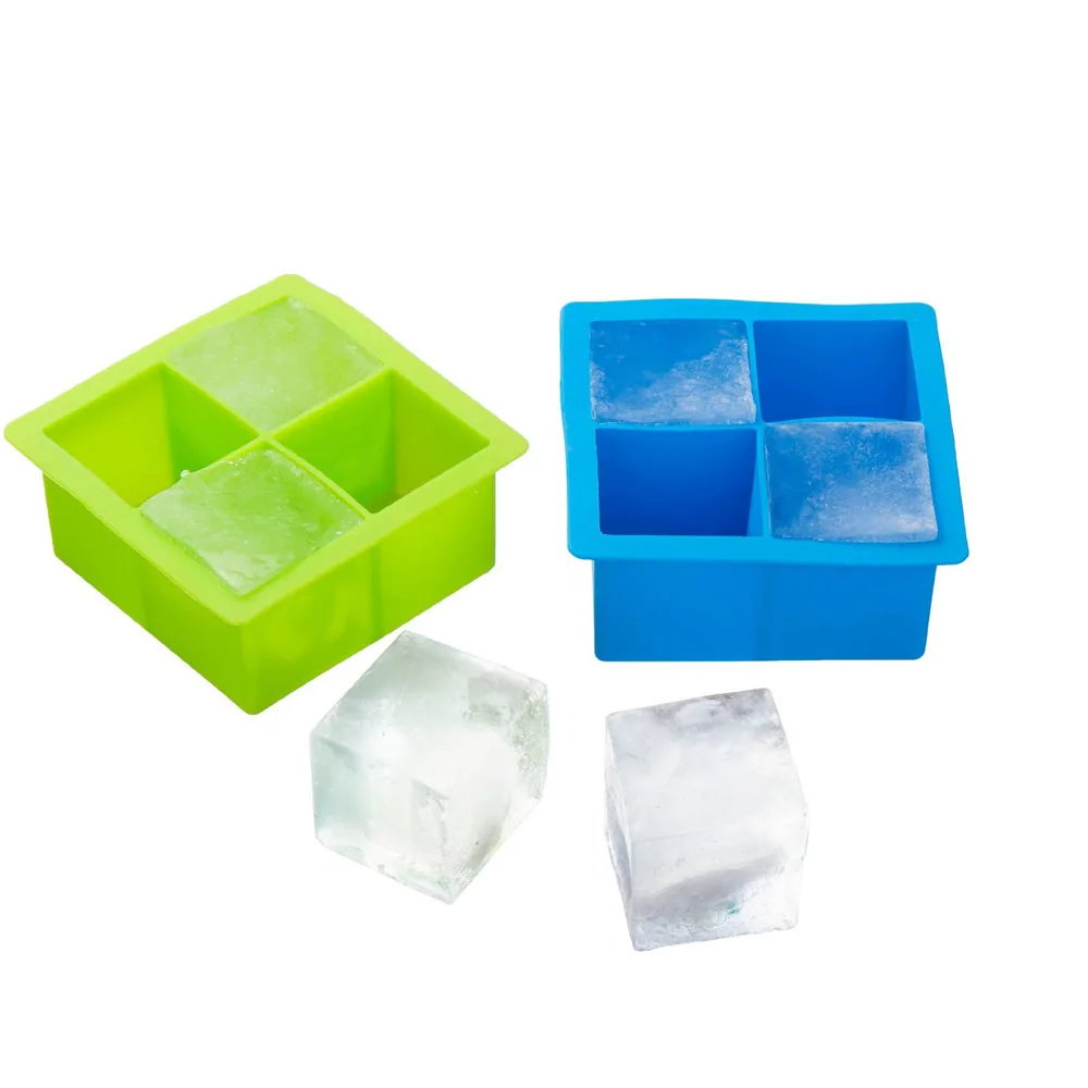 Green and blue four-compartment ice trays with large square ice cubes on a white background